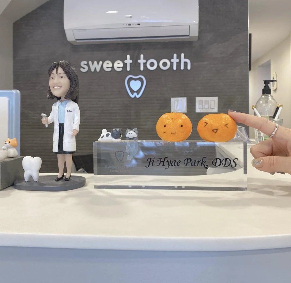 Welcoming front desk display at Sweet Tooth Dental Care with a dentist figurine, office signage, and playful decorations.